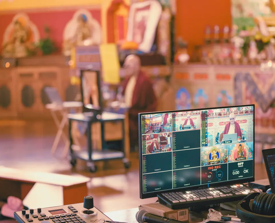A teacher leads a session in the temple while a production desk streams it online